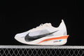 Side view of a white Nike Vaporfly 4 with black Swoosh and orange sole accent.
