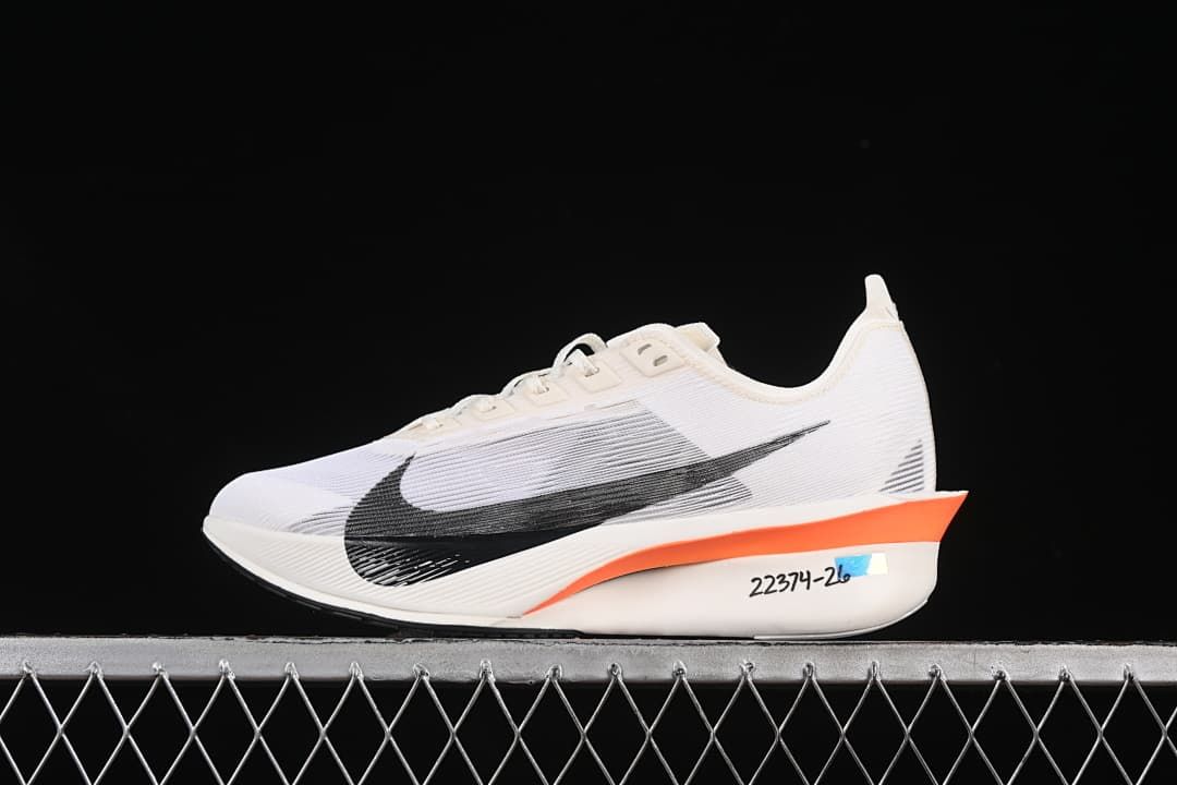 Side view of a white Nike Vaporfly 4 with black Swoosh and orange sole accent.