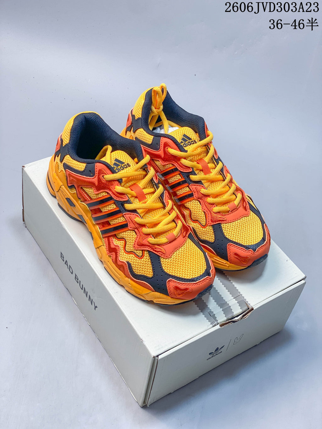 Yellow, orange, and navy adidas Response CL sneakers displayed on a Bad Bunny box