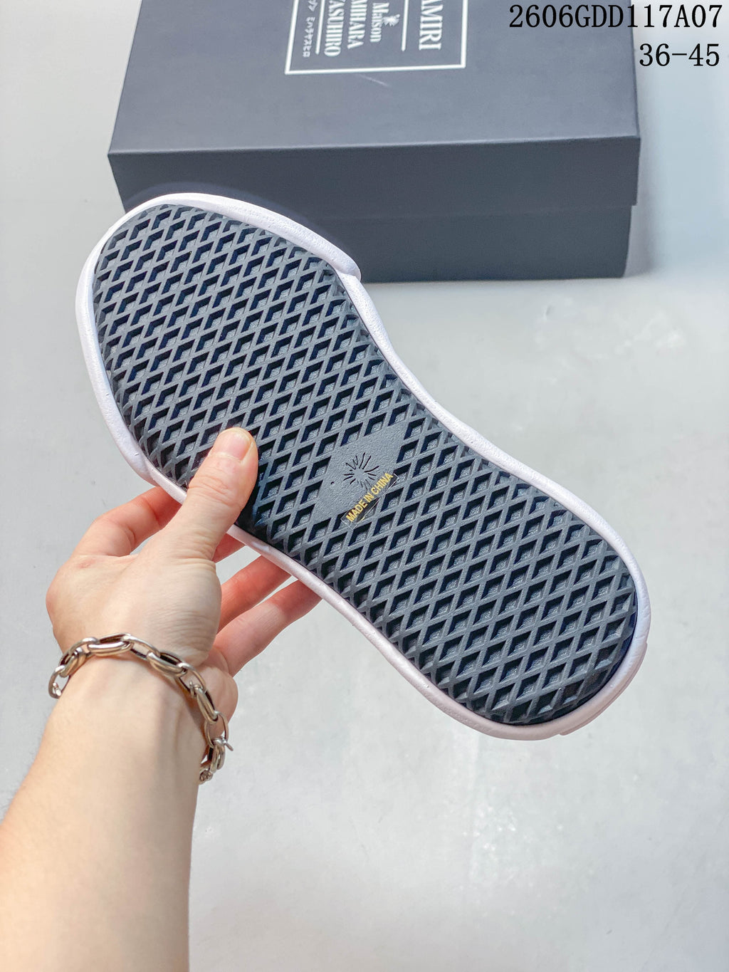 Close-up of the patterned outsole on a navy and white sneaker