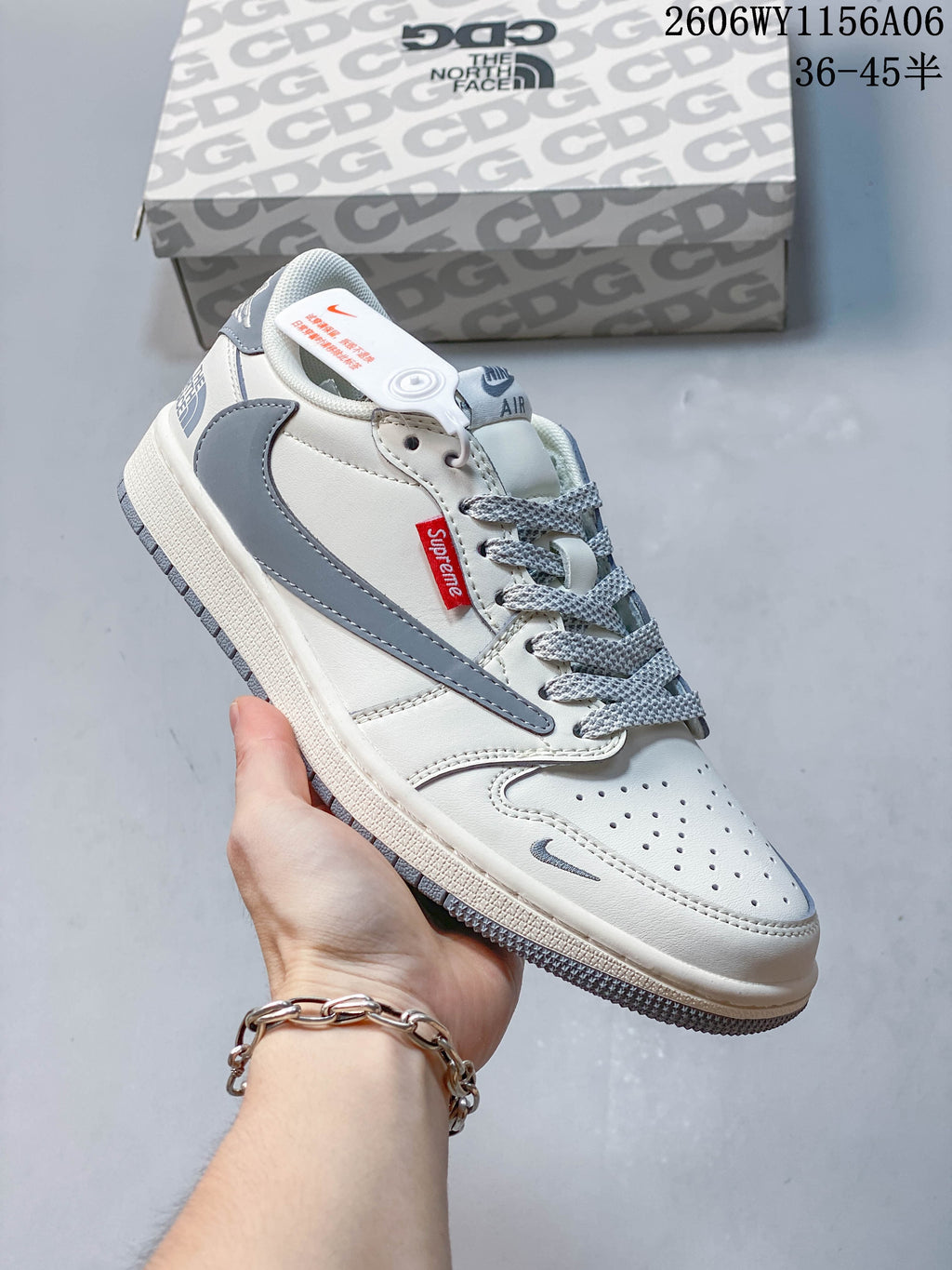 White and gray low-top sneaker shown from the side with a gray accent panel