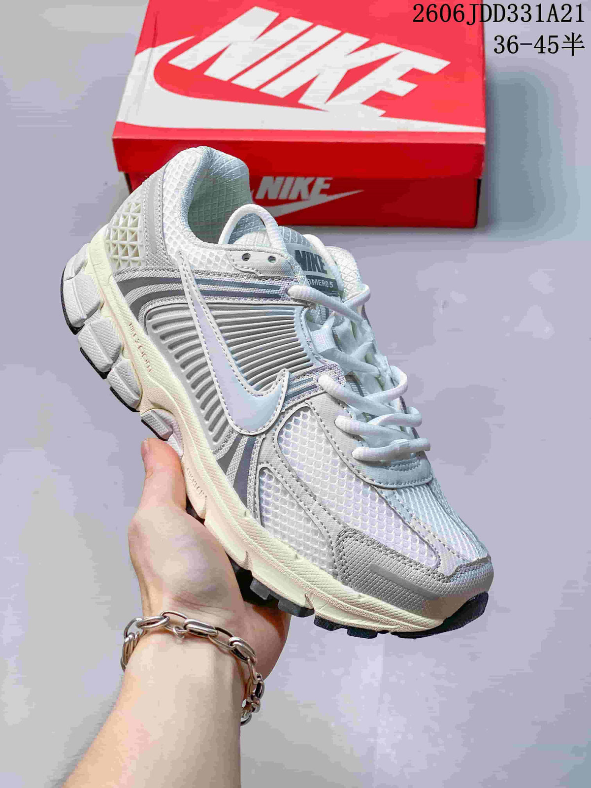 Angled view of a white and grey Nike Zoom Vomero 5 sneaker