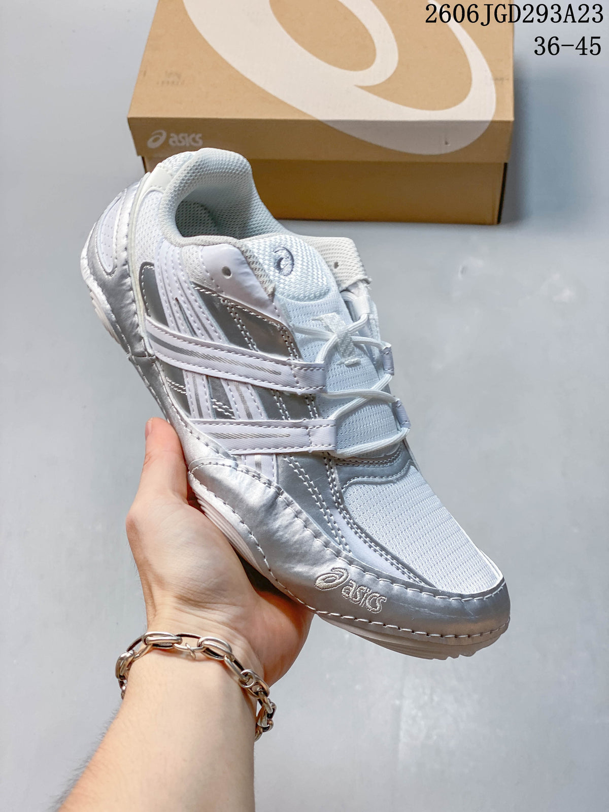 Angled view of the white and silver sneaker with layered side panels.