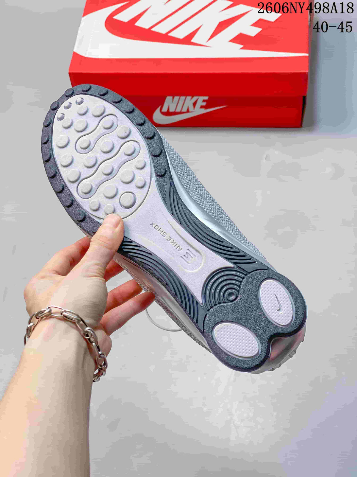 Nike Shox TL sneaker outsole with textured tread, shown beside a red box