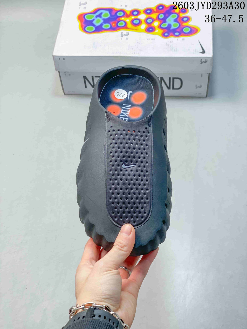 Top view of a dark gray Nike Mind slide with a perforated panel