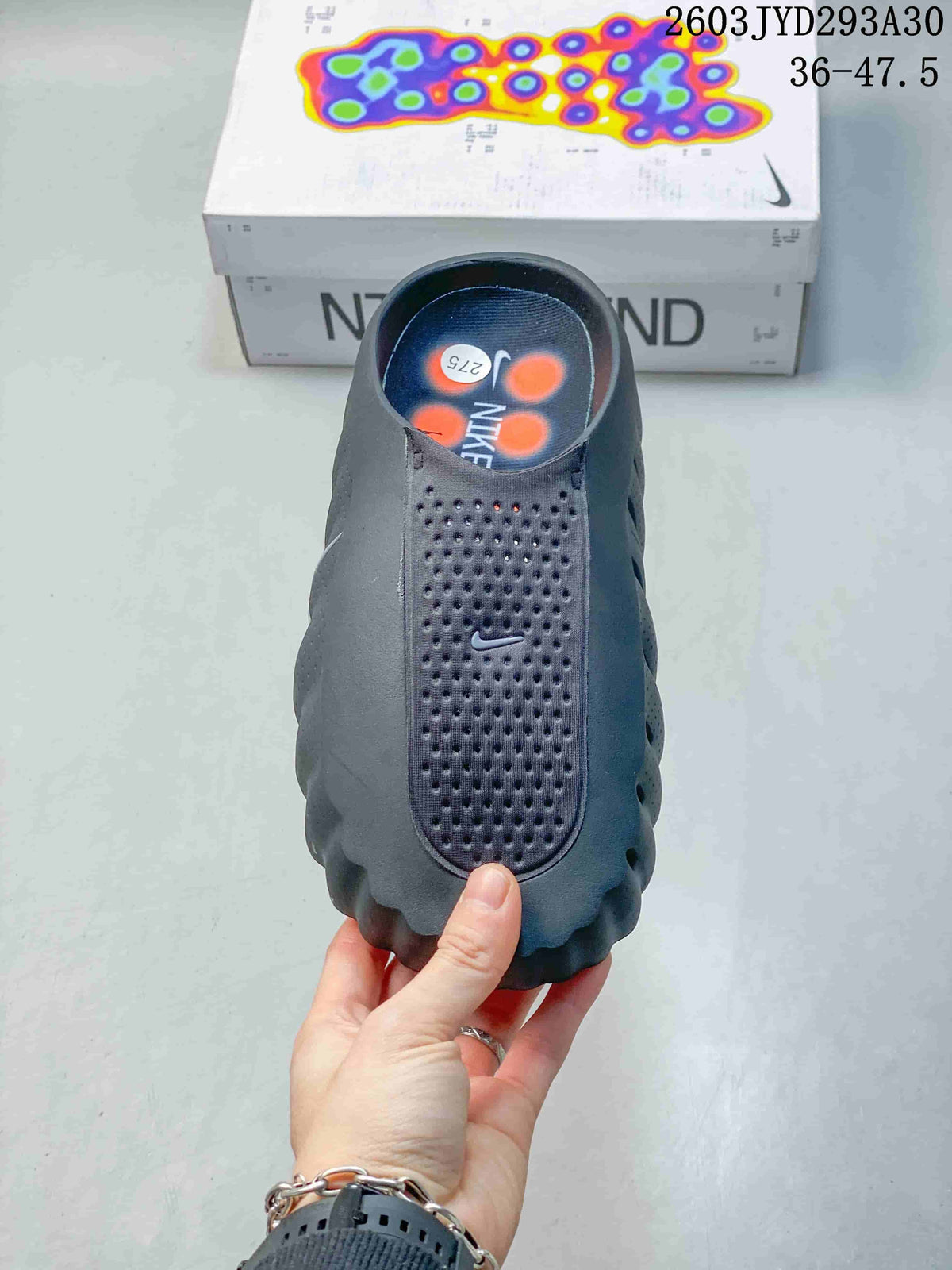 Top view of a dark gray Nike Mind slide with a perforated panel