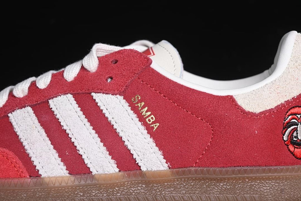 Close-up of the red upper, off-white side stripes, white laces, and Samba lettering.