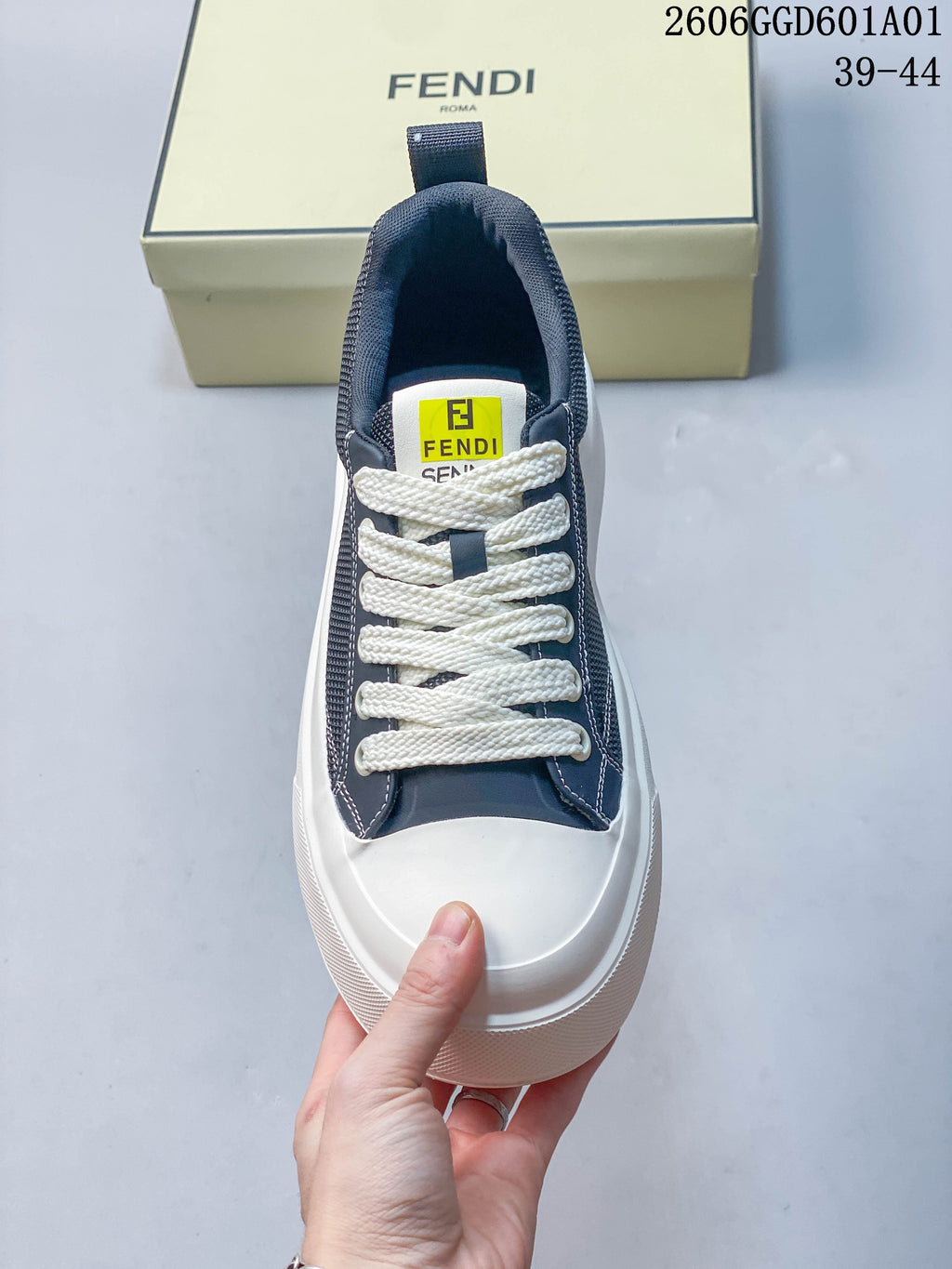 Front view of a navy and white sneaker with a contrasting toe cap and branded tongue label.