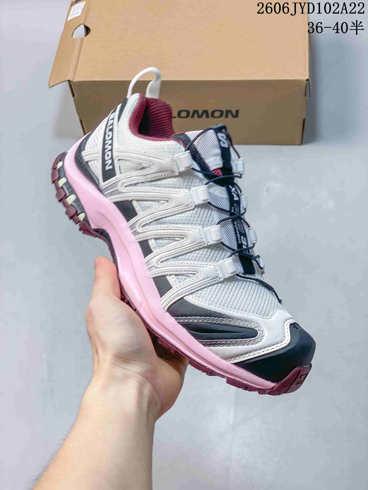 Side view of a white Salomon XA Pro 3D shoe with pink and navy accents