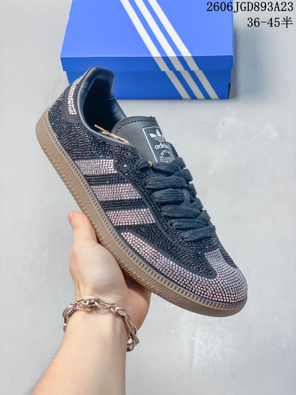 Angled side view of the dark sneaker with silver-toned embellishment