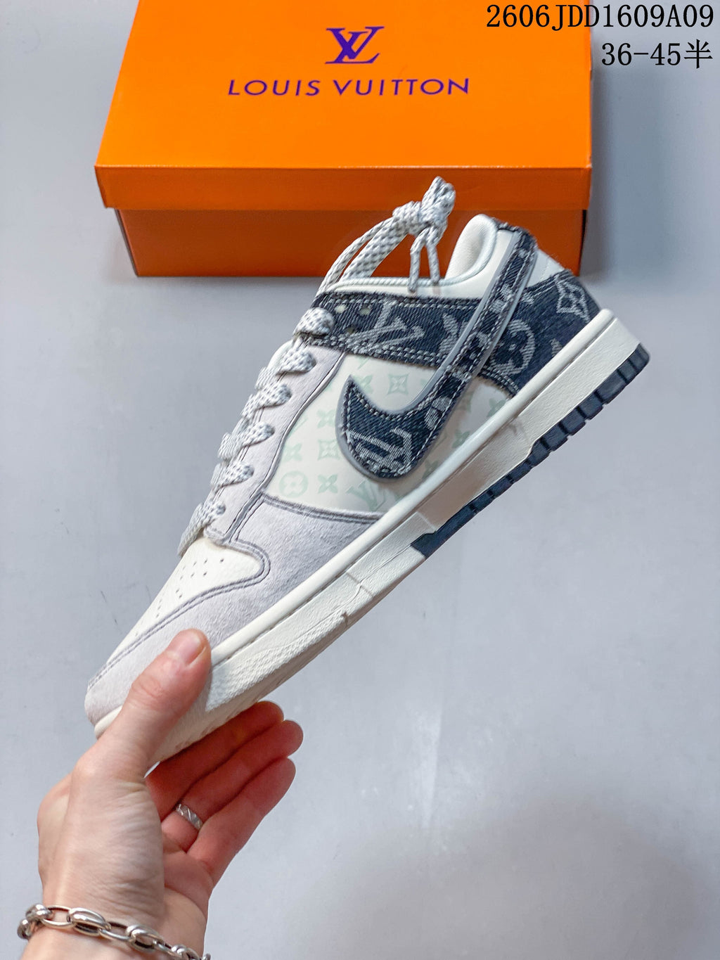 Side view of a cream and gray low-top sneaker with printed panels and a dark patterned Swoosh