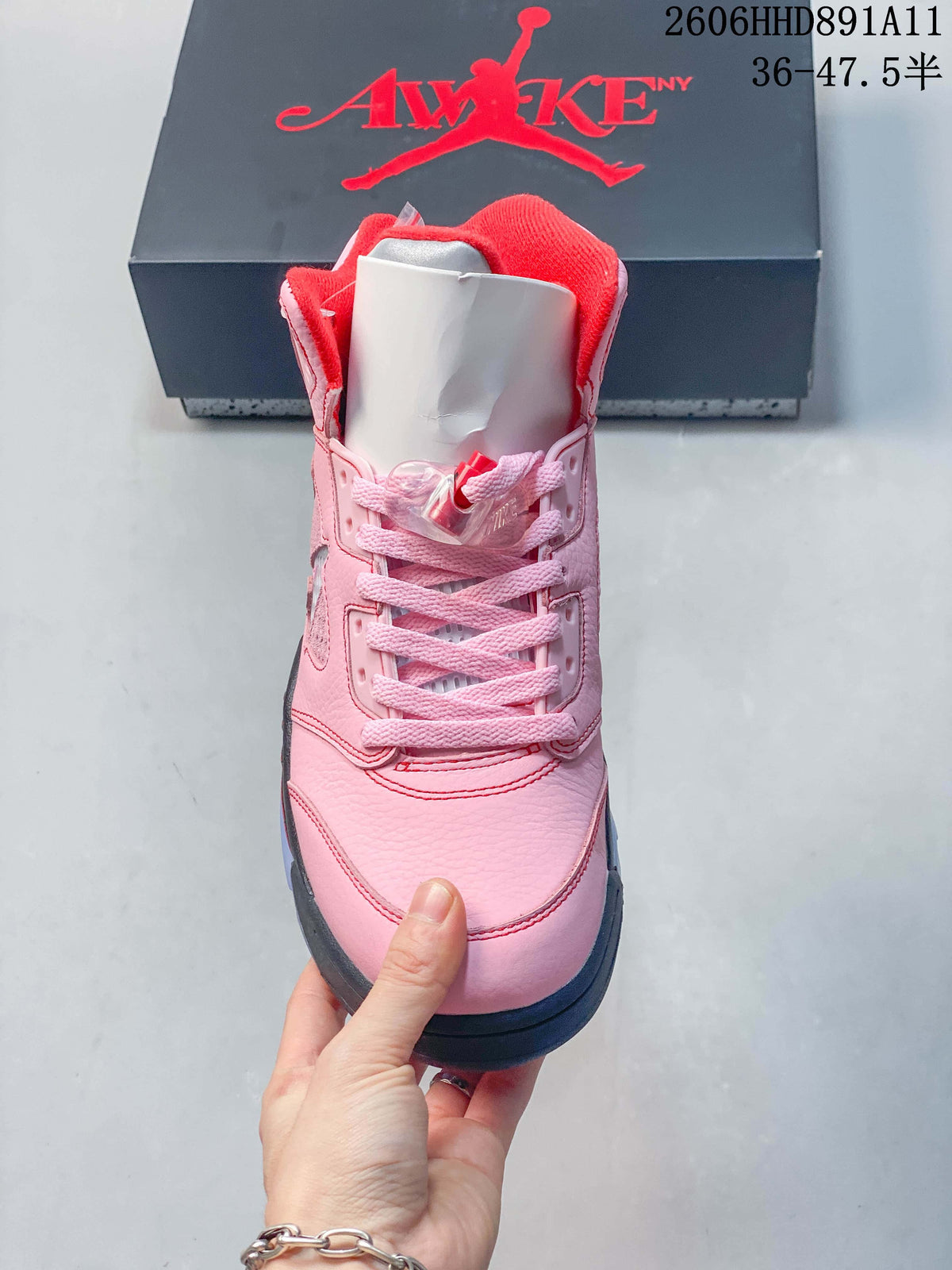 Front view of the pink sneaker showing its laces, tongue, and red collar lining.