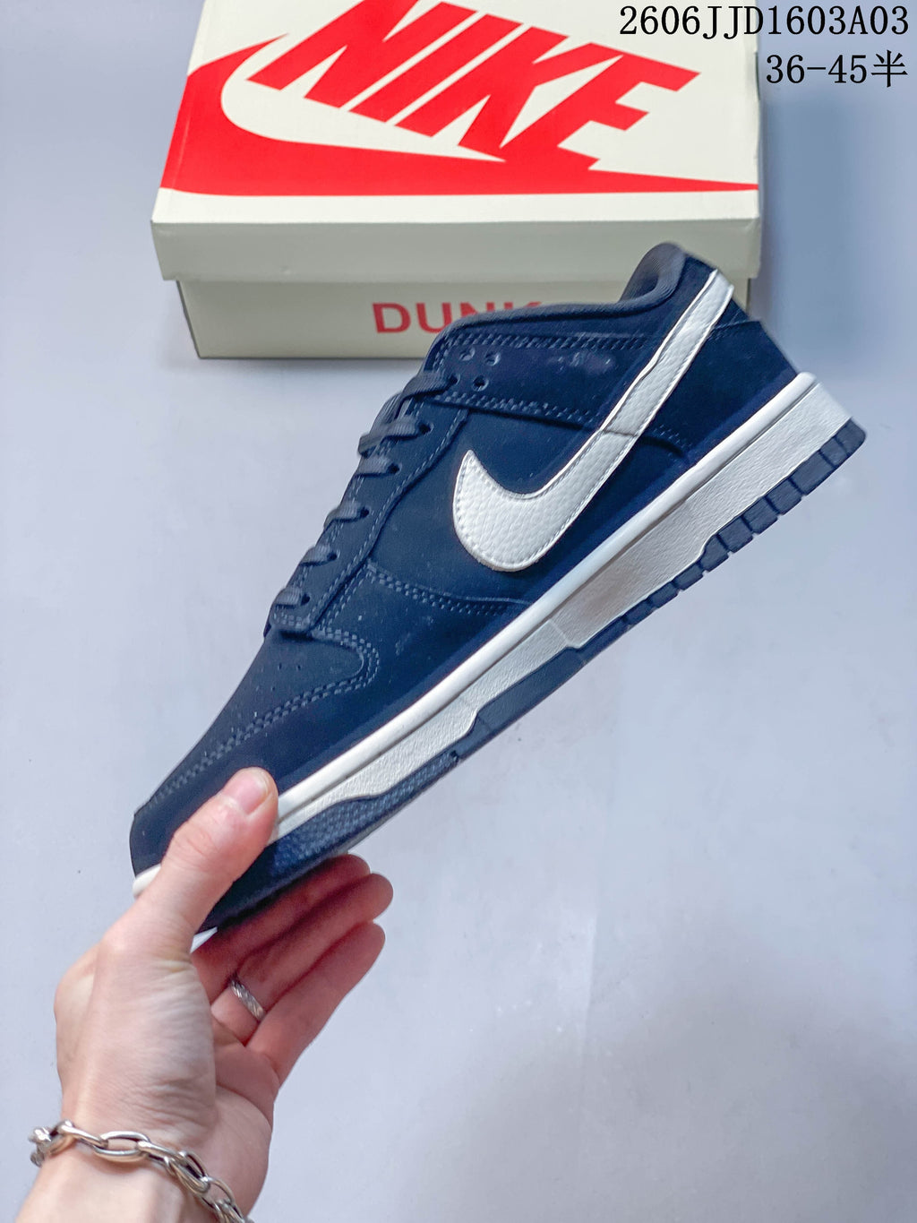 Side view of a navy low-top sneaker with a cream Swoosh and midsole