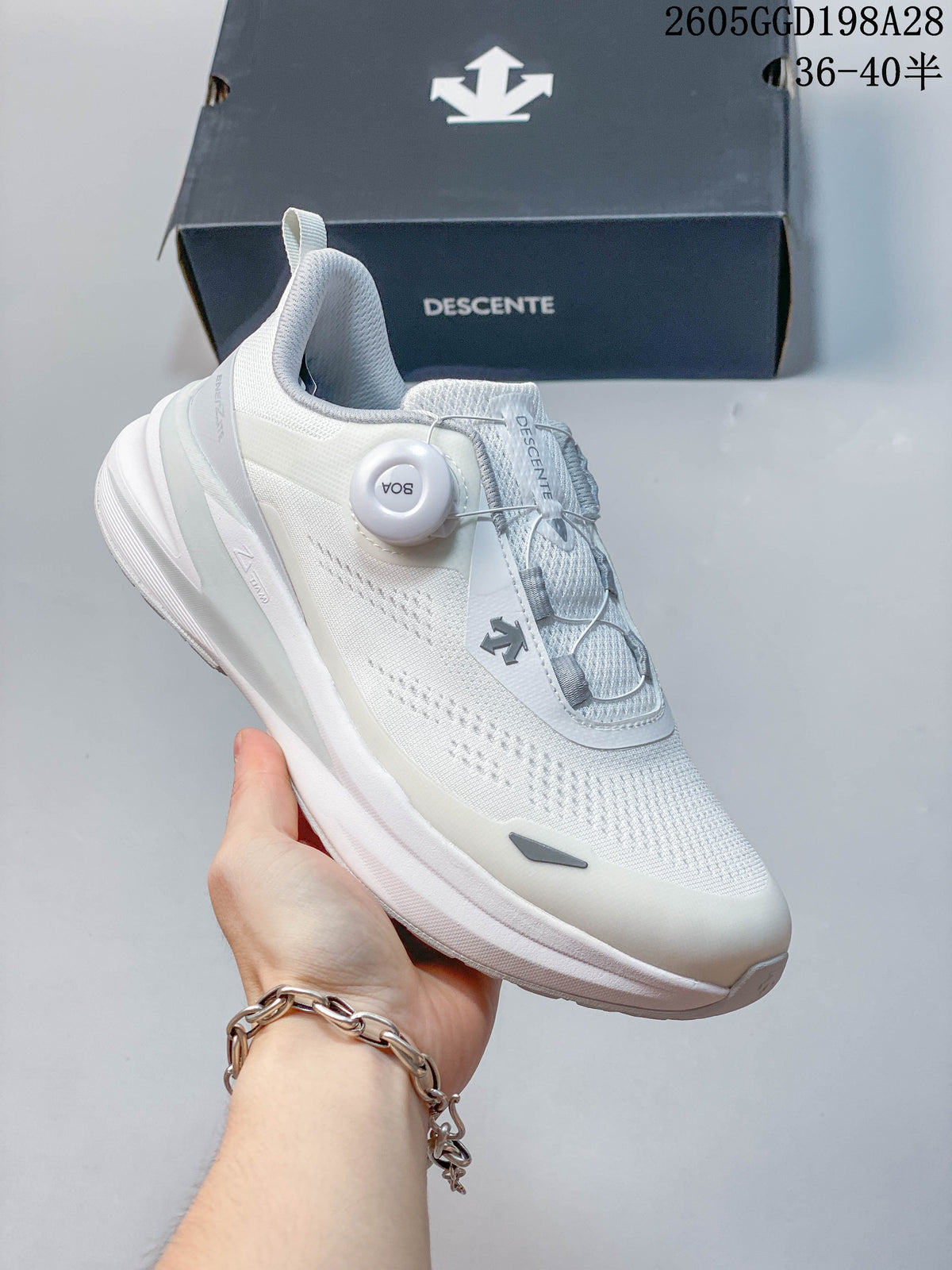 Angled view of the white DESCENTE sneaker and its BOA dial closure