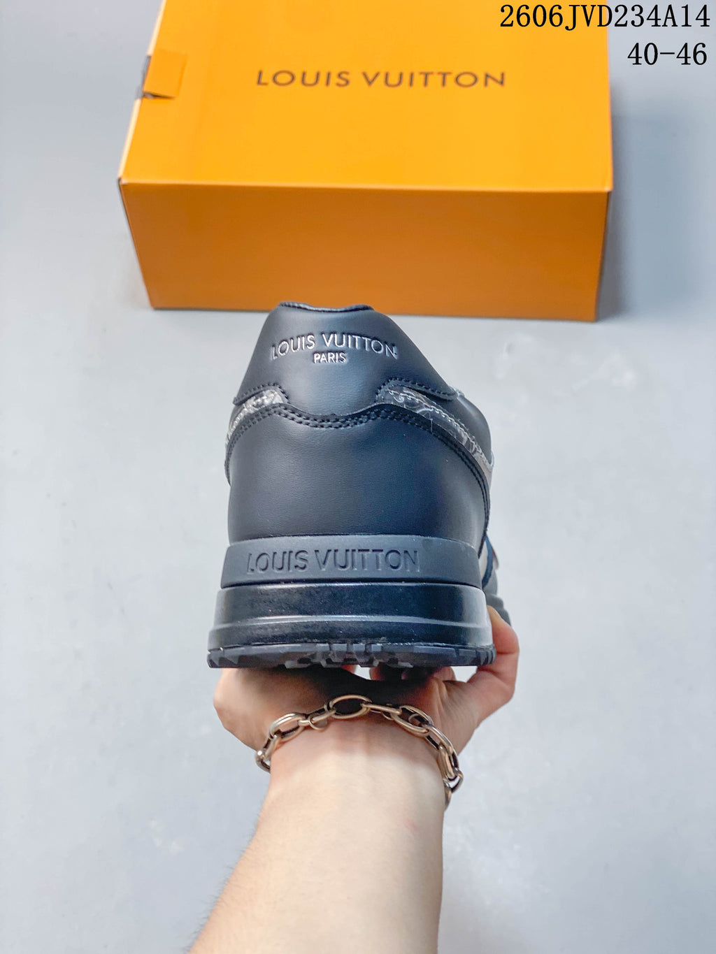 Rear view of the gray sneaker showing the heel, layered sole, and branded details