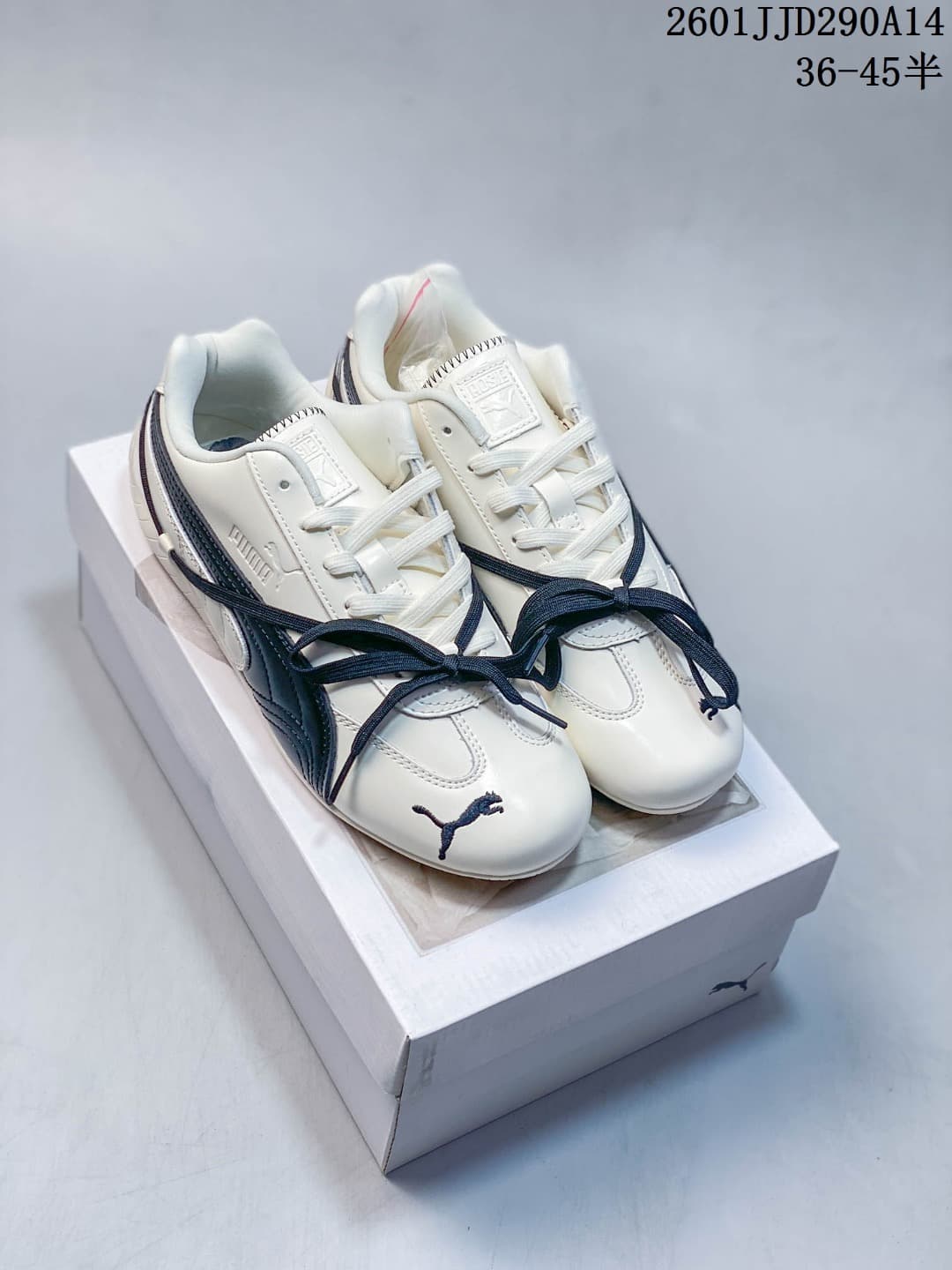 Pair of cream PUMA Speedcat TTF sneakers with navy accents and contrasting crossover laces.