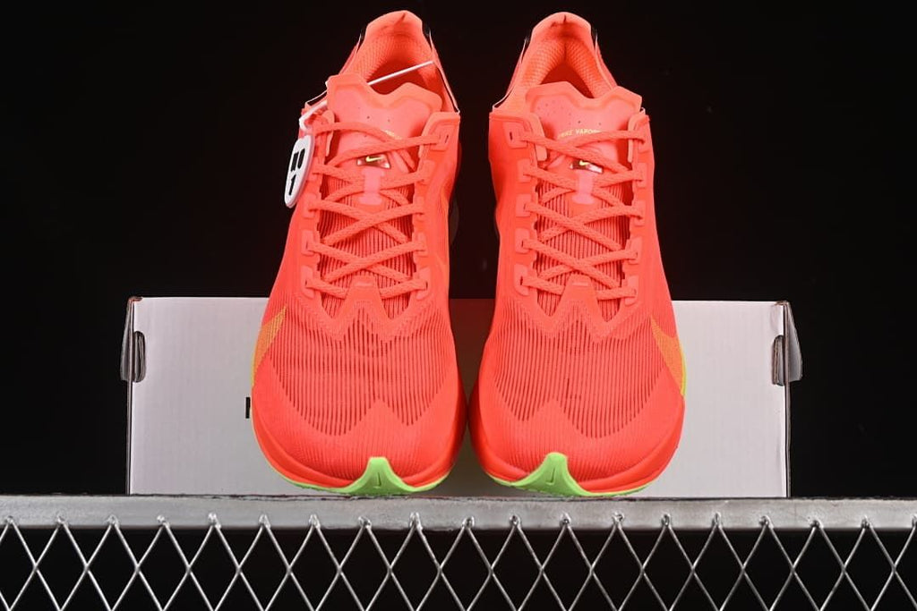Front view of the pair showing the coral uppers, laces and yellow-green toe accents.