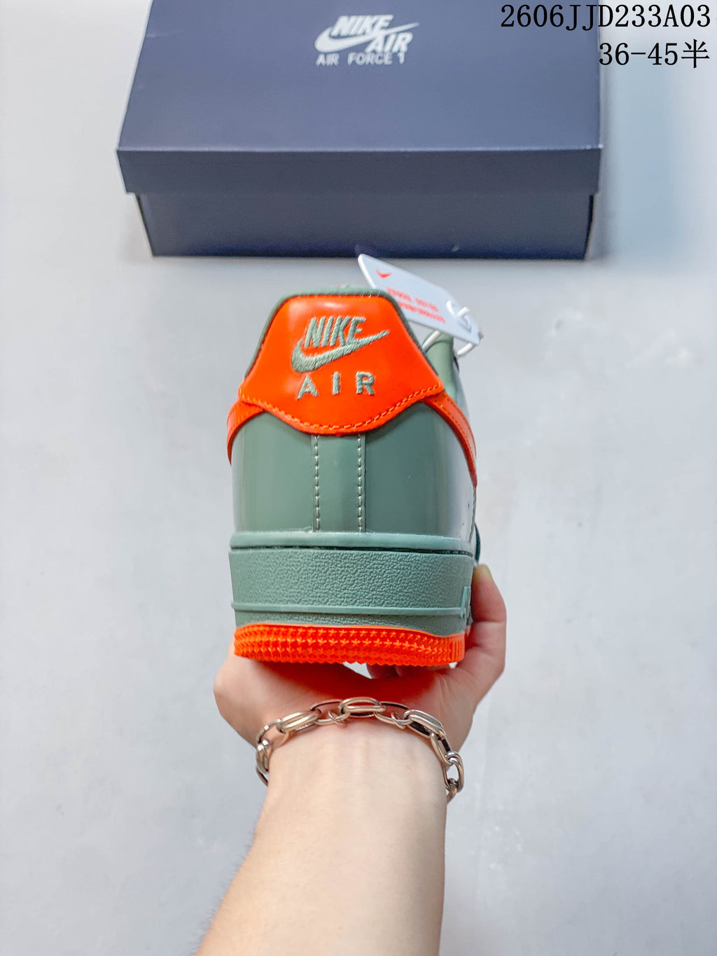 Rear view showing the orange heel tab on a green Air Force 1 ’07 sneaker
