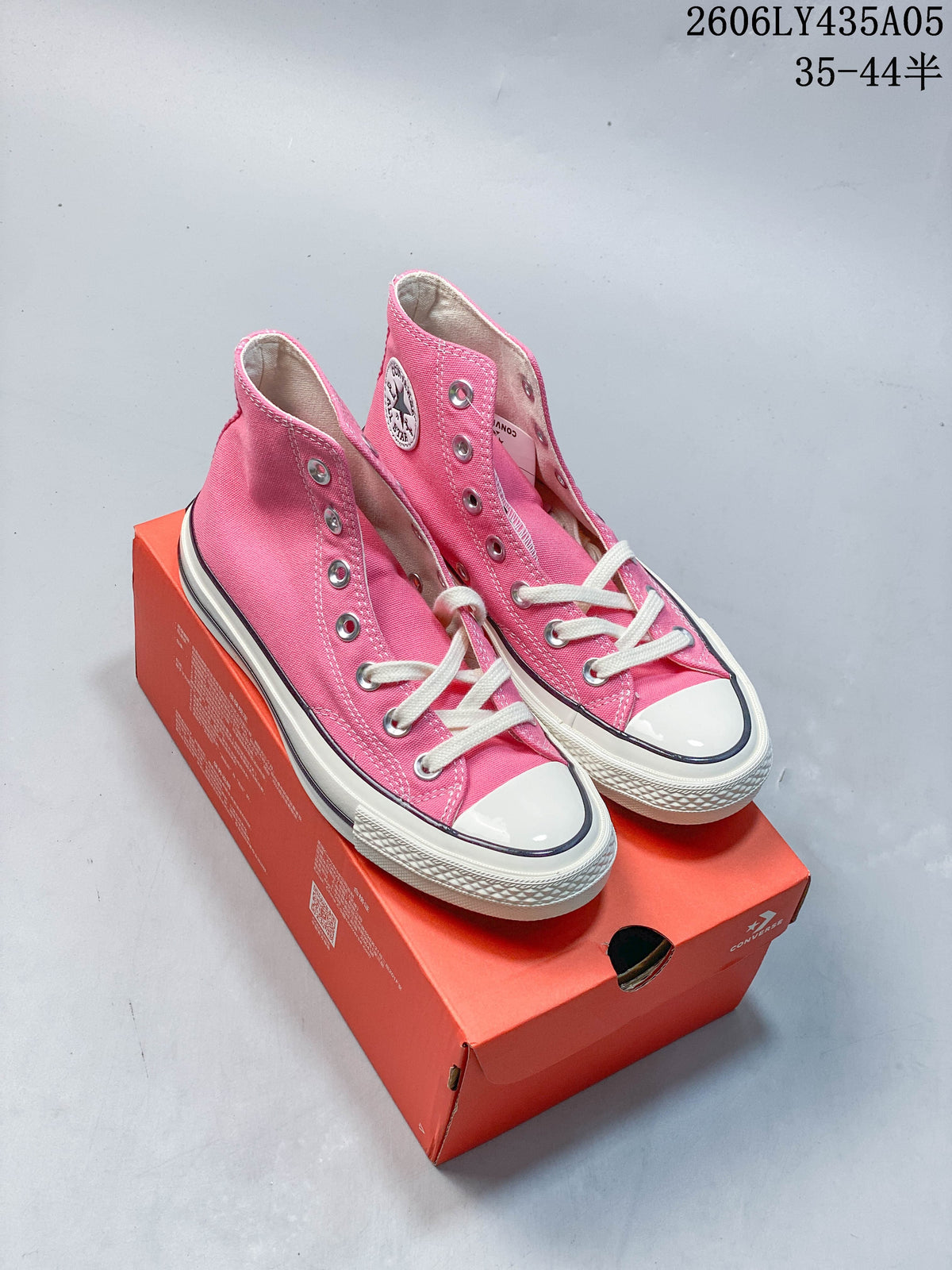 Pink Converse Chuck Taylor 1970s-style high-top sneakers displayed on a red shoebox