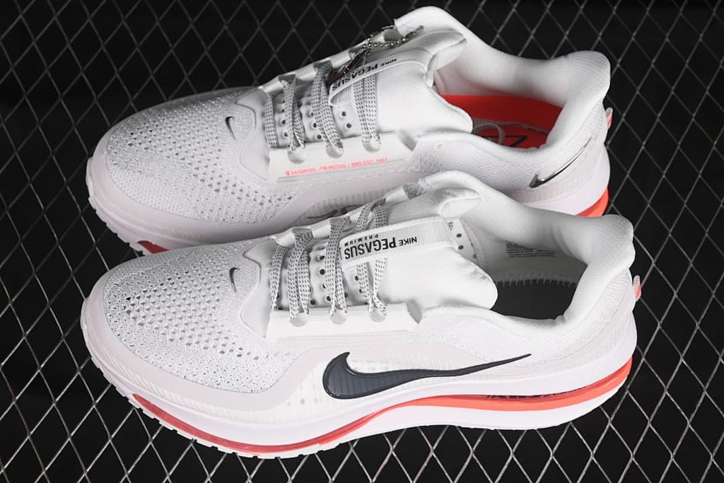 Pair of white running shoes with dark Swoosh details and red accents.