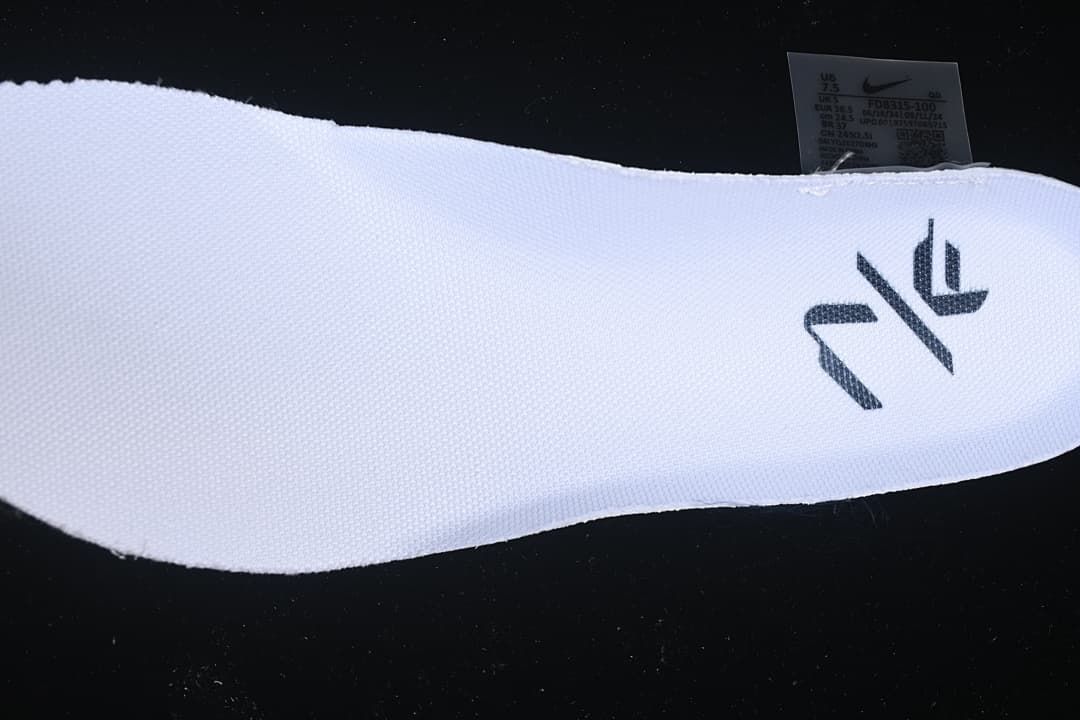 Close-up of the white knit-look upper, dark graphic and shoe label.