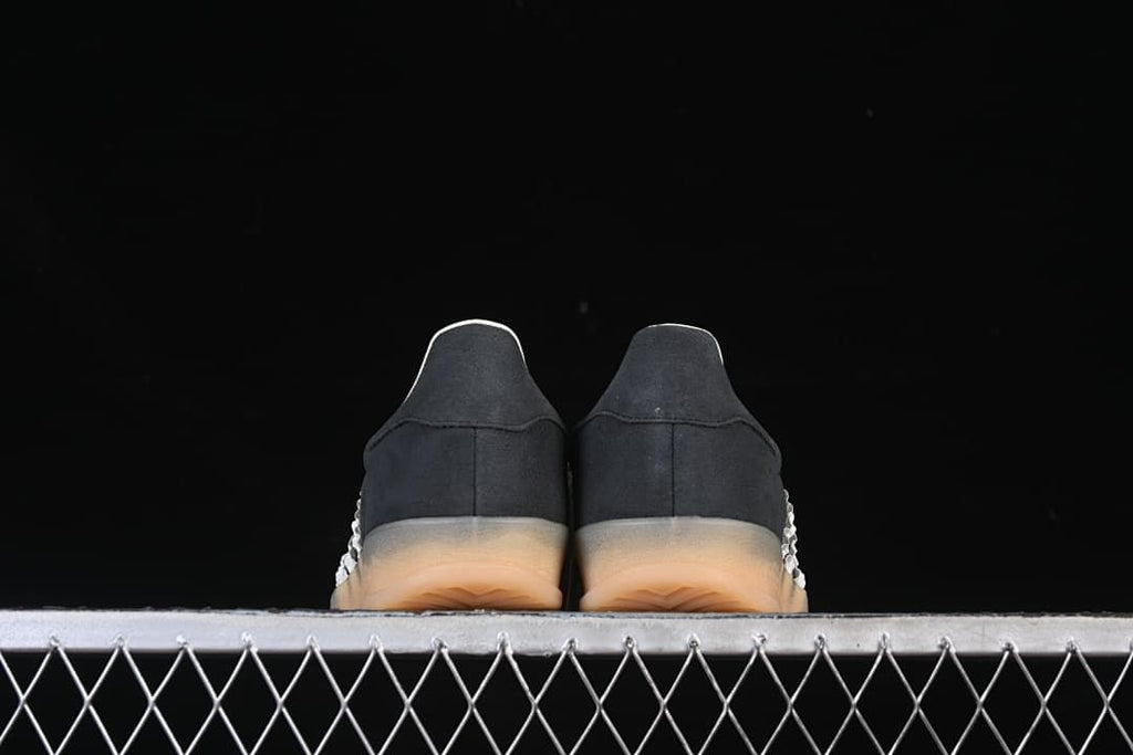 Rear view of both sneakers showing the heels and gum-colored soles.
