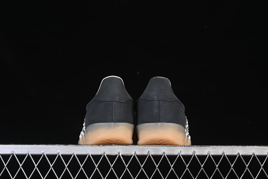 Rear view of both sneakers showing the heels and gum-colored soles.