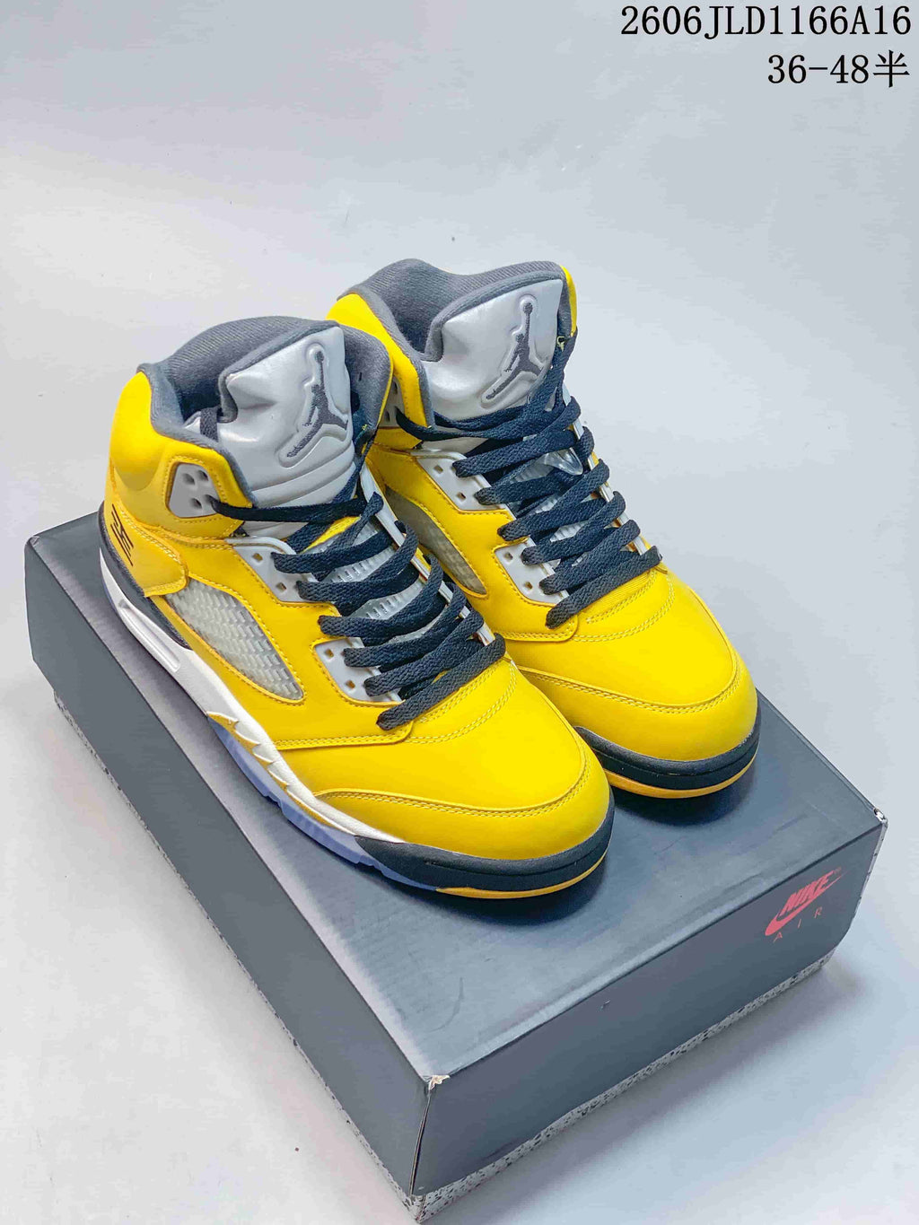 Pair of yellow and grey Air Jordan 5 Retro high-top sneakers on a shoebox