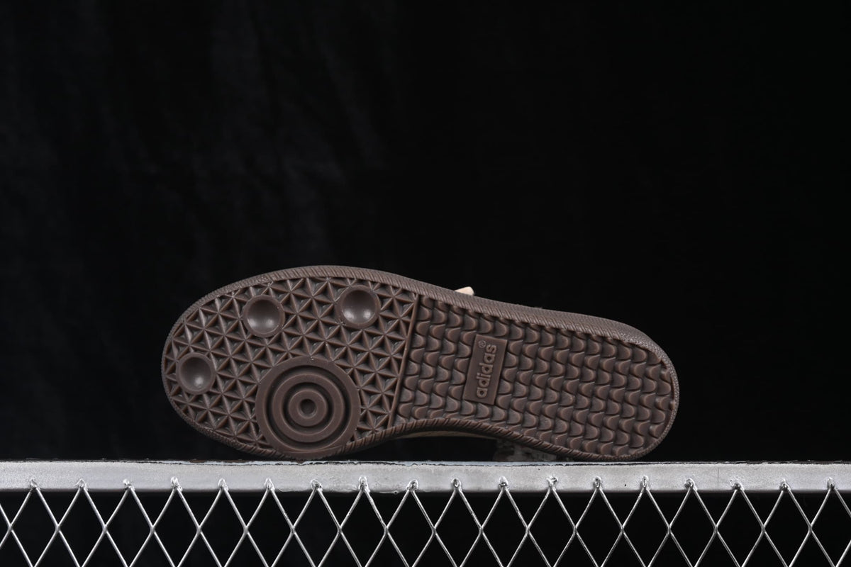 Underside of the sneaker showing the dark rubber outsole with geometric tread patterns and adidas branding.