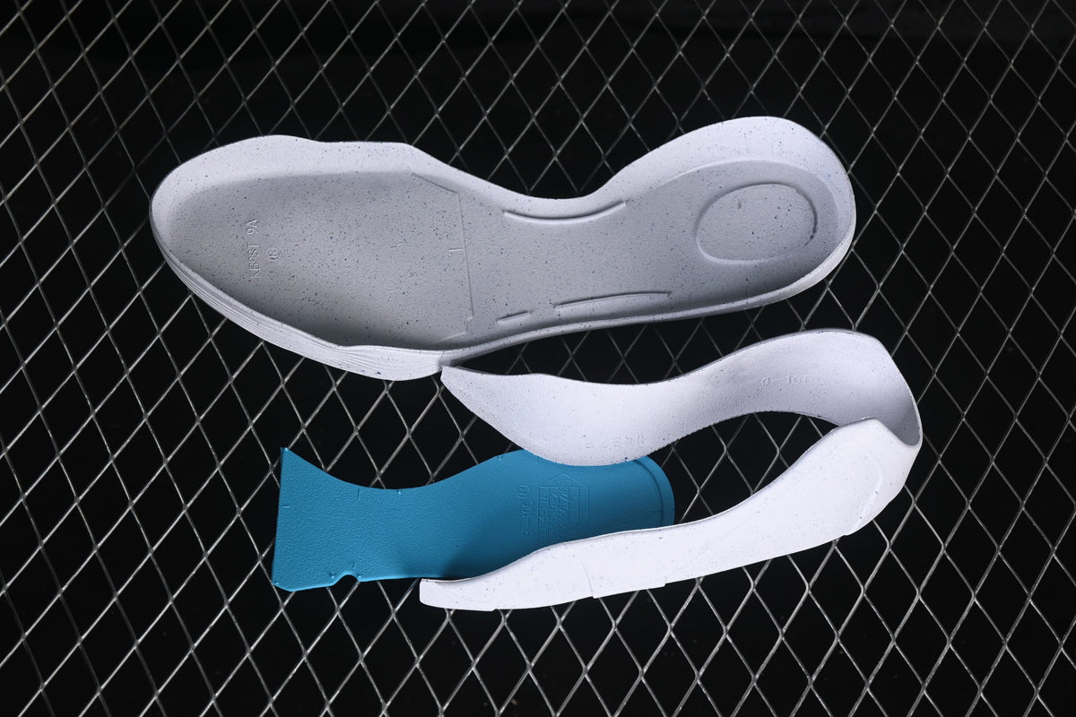 Separated shoe components displayed on a mesh surface.