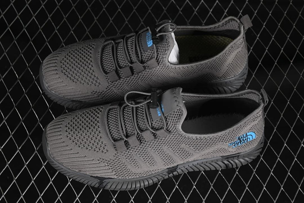 Pair of gray shoes with toggle laces and dark grooved outsoles