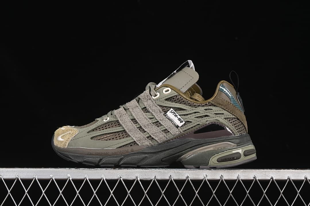 Side view of an olive and gray adidas Adistar Cushion sneaker against a black background.