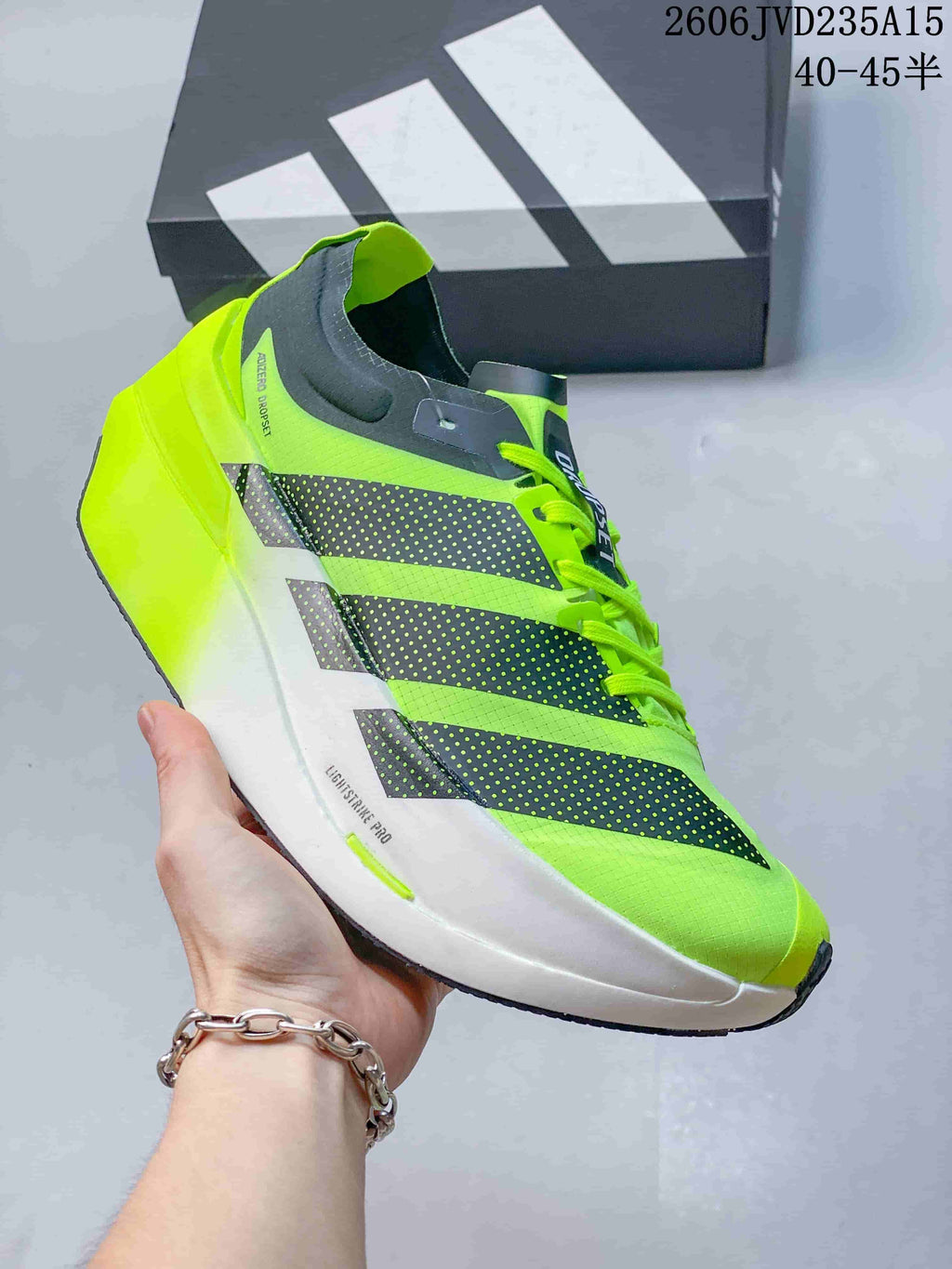 Side view showing the Adidas stripes, white midsole, and neon green upper