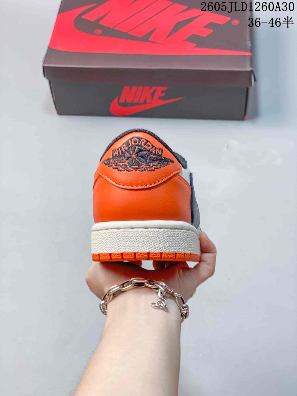 Rear view of the orange heel and embroidered logo on a Jordan low-top sneaker
