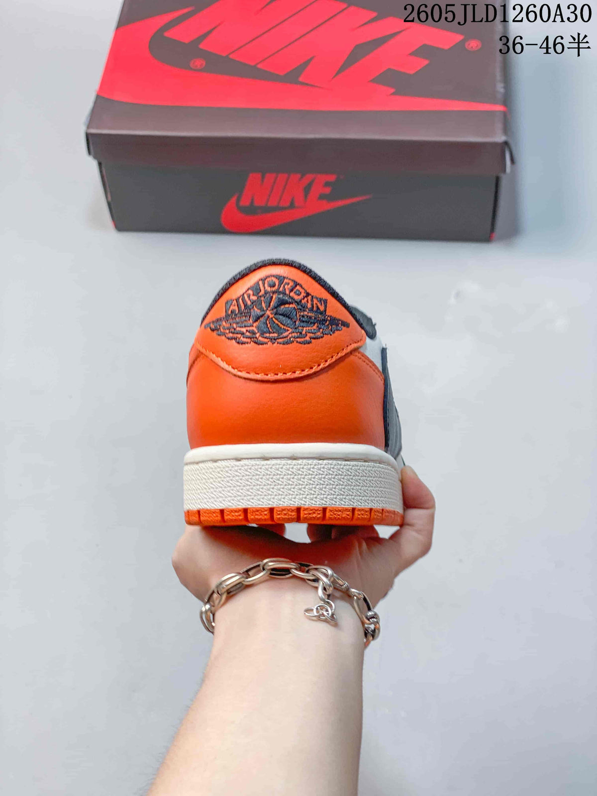 Rear view of the orange heel and embroidered logo on a Jordan low-top sneaker