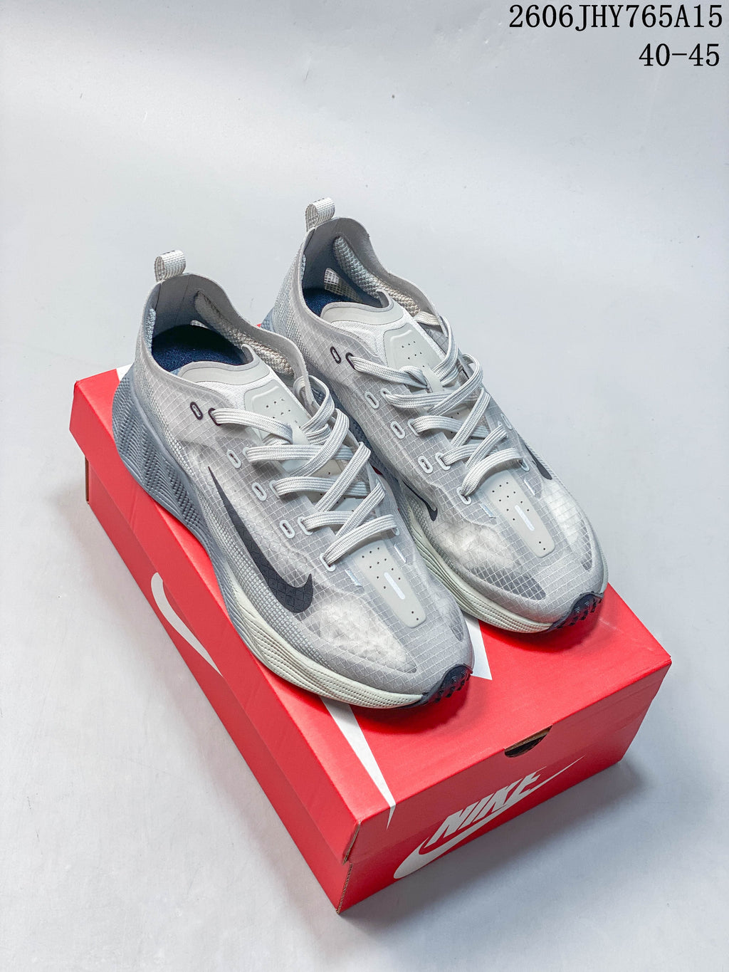 Pair of grey Nike Ava Rover low-top running shoes shown from above on a red shoe box