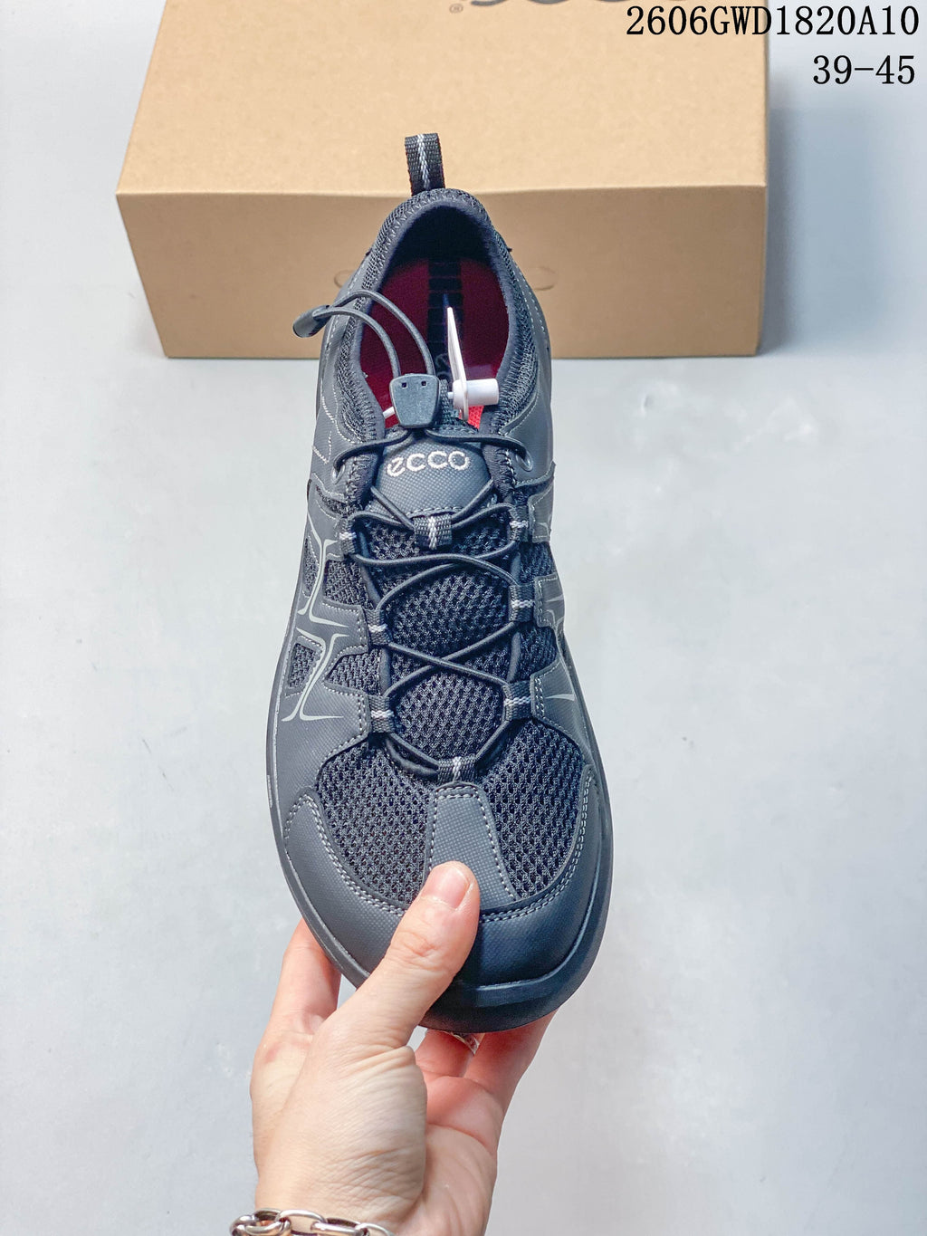 Top view of the grey sneaker showing mesh panels and quick-lace closure; image shows style code 2606GWD1820A10 and a 39–45 size range.