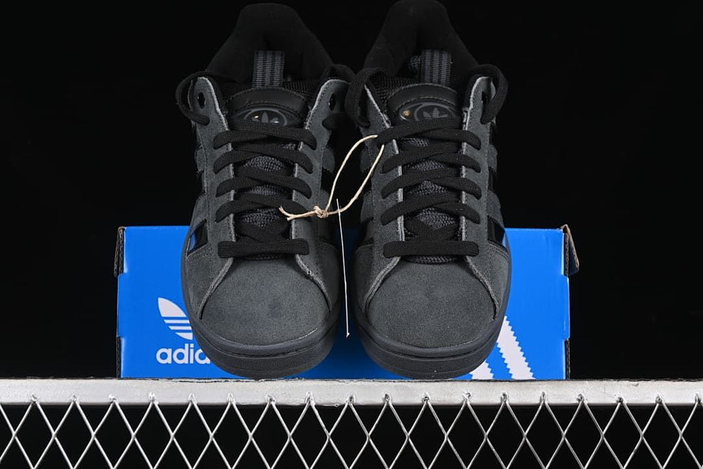 Front view of the pair of charcoal gray sneakers on a blue box