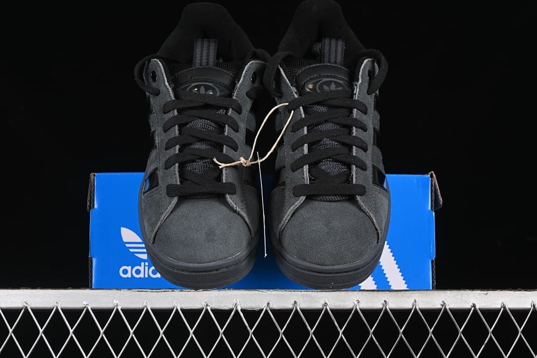 Front view of the pair of charcoal gray sneakers on a blue box