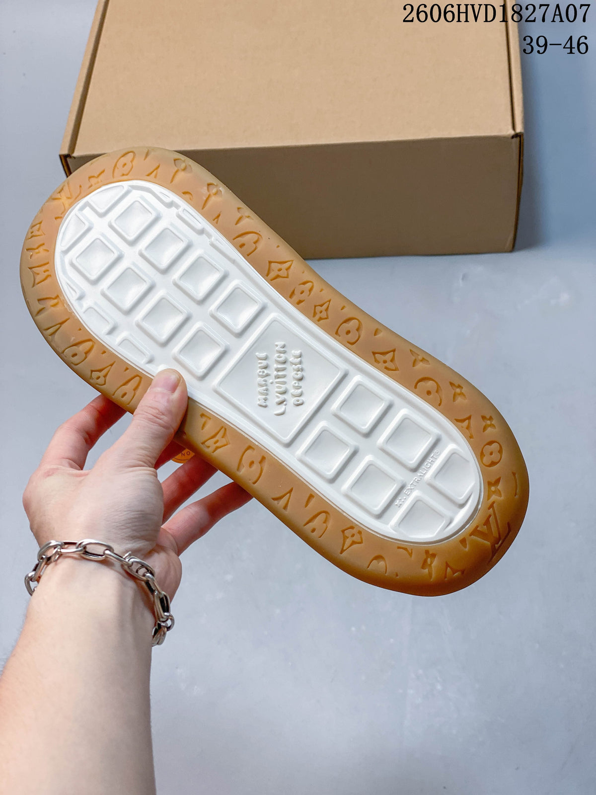 Underside of the sneaker showing a white tread center and gum-colored outsole with embossed motifs.