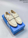 Pair of cream adidas Handball Spezial loafer-style shoes with white stripes and textured dark soles