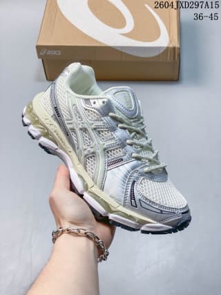 ASICS low-top sneaker in a pale sage, gray, and off-white colorway, shown with a branded shoe box.