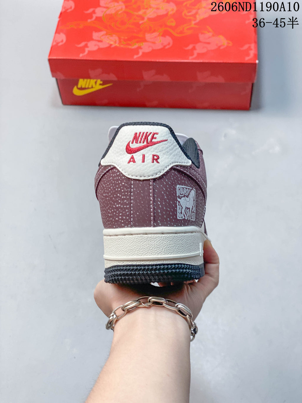 Rear view of the sneaker showing a burgundy heel panel and off-white heel tab