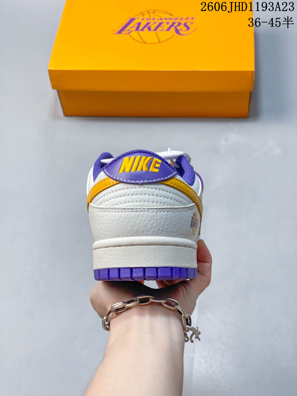 Rear view of the sneaker showing purple heel tab, gold Nike lettering, and Lakers detail