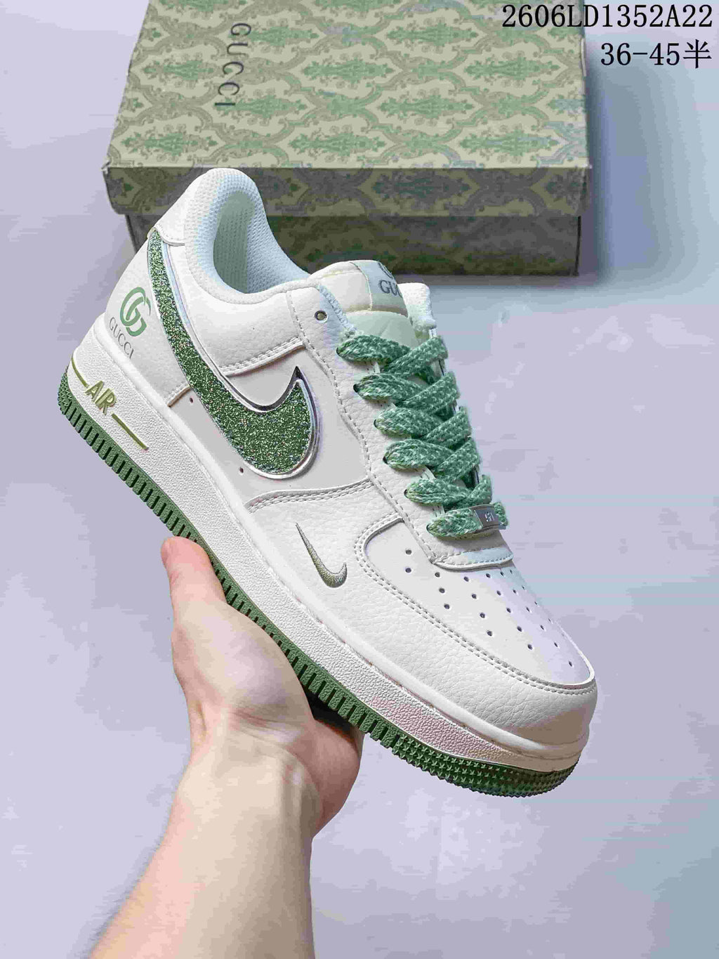White low-top sneaker with green accents, patterned laces and glitter-effect Swoosh.