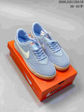 Pair of light blue Nike Astrograbber low-top sneakers on an orange shoebox