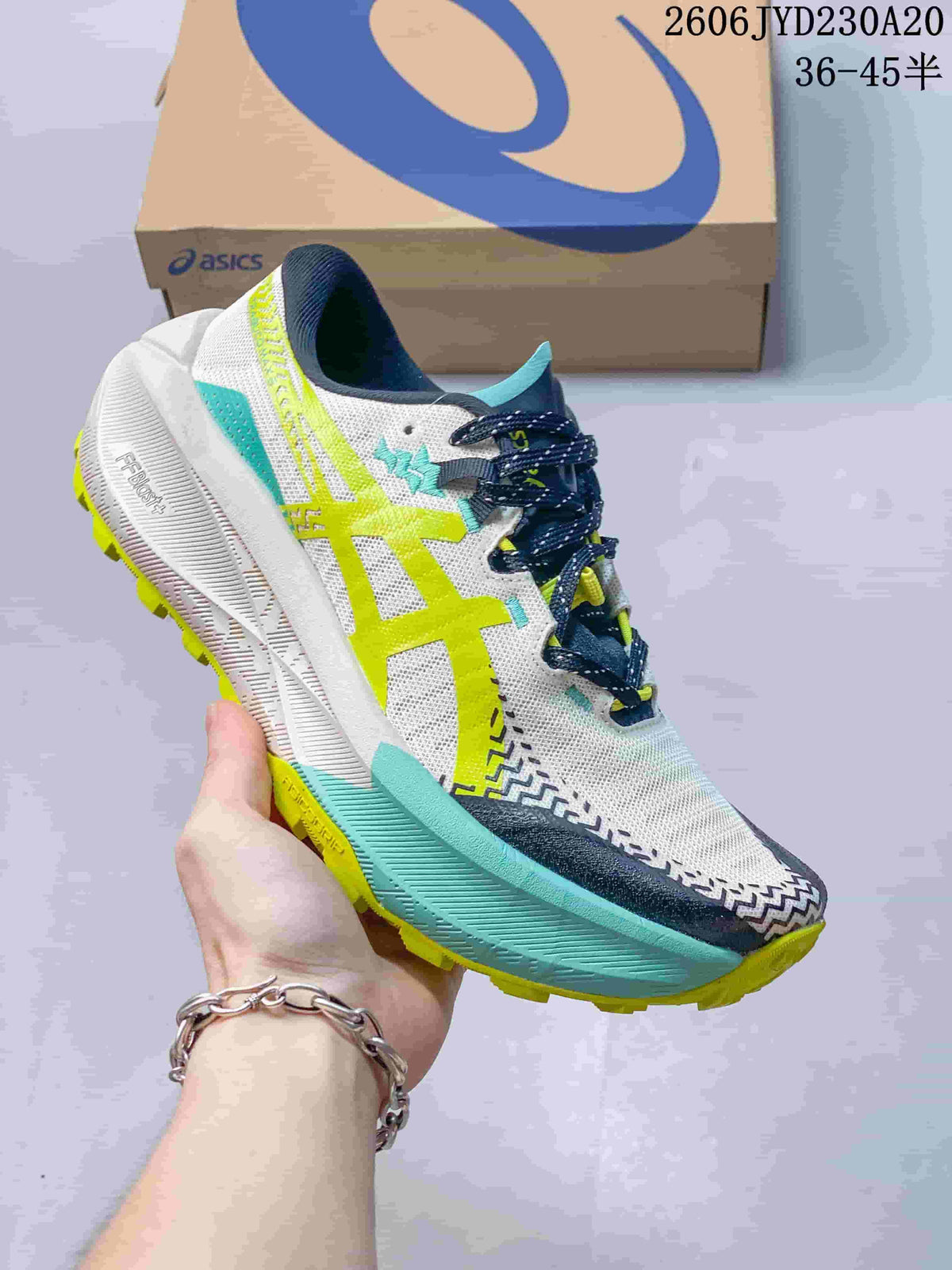 Side view of a white ASICS GEL-TRABUCO MAX 5 shoe with aqua and lime accents