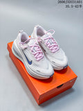 White Nike Vomero Plus shoes with pale pink laces and blue-gray accents on an orange shoe box.