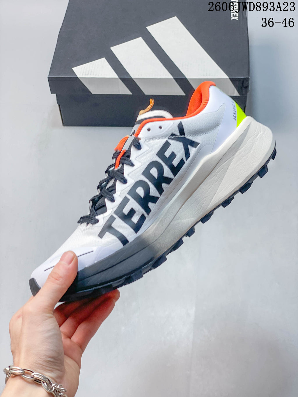 Side view of the white trail running shoe with dark gray accents.