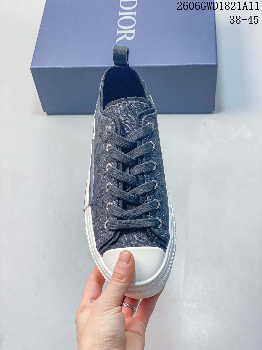 Front view of a gray lace-up sneaker with a white toe cap and metal-tone eyelets